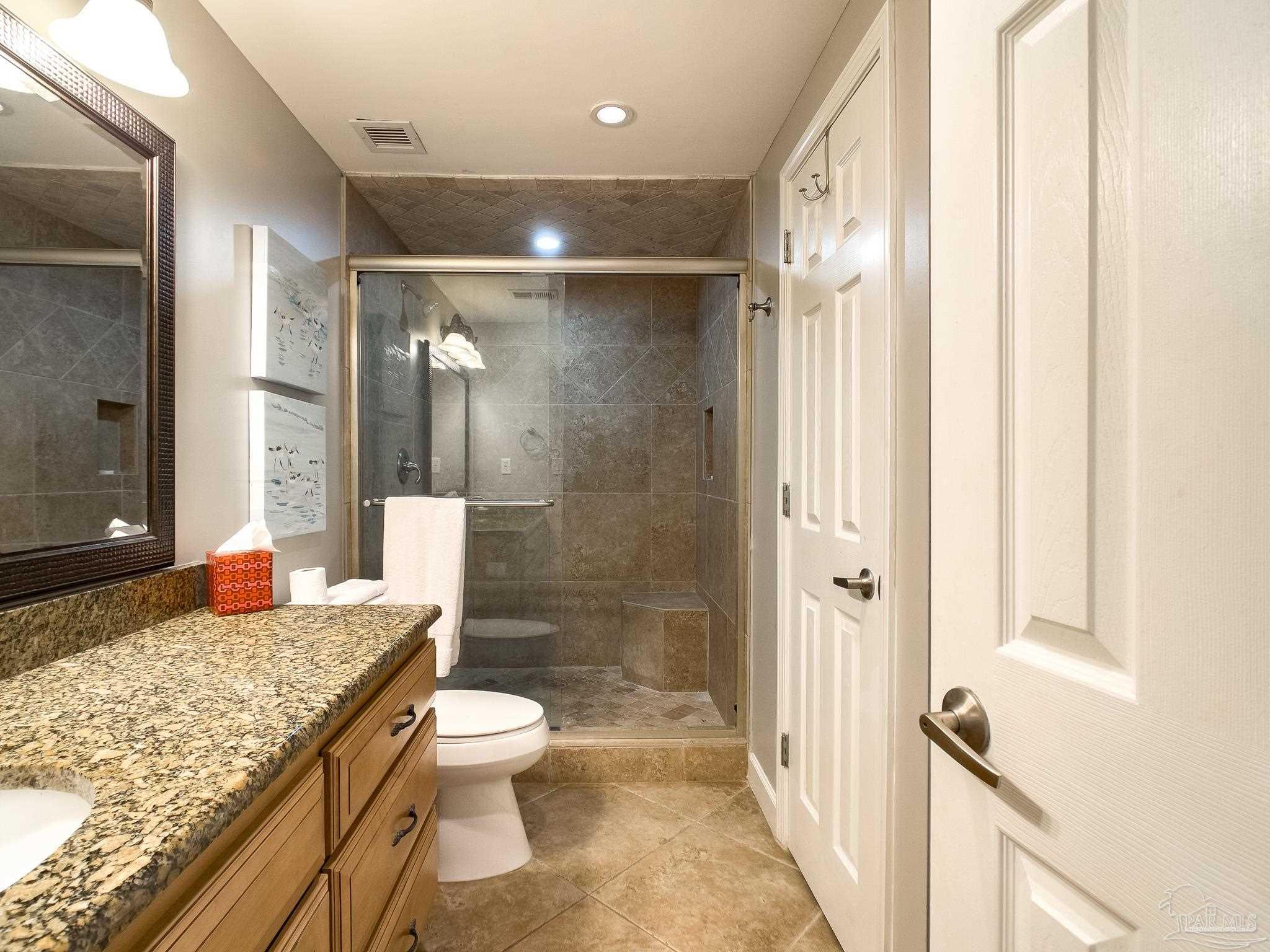 16287 Perdido Key Drive, Unit 104 Pensacola, FL 32507 - Photo 16 of 32 a bathroom with a granite countertop sink toilet and shower