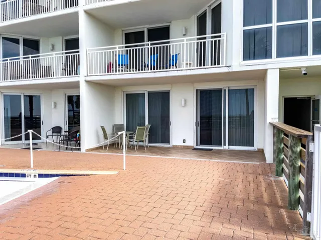 a front view of a house with swimming pool and furniture