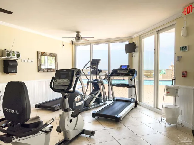 a room with gym equipment and large windows