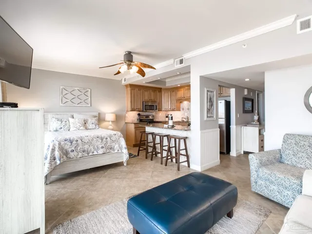 a bedroom with a bed a couch and a potted plant