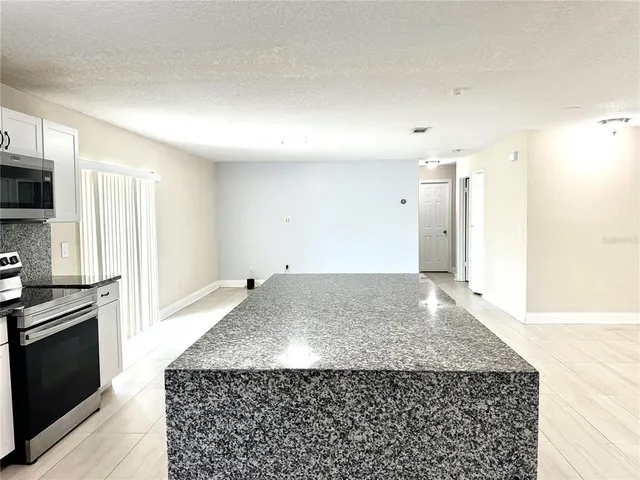 a bathroom with a granite countertop sink and washing machine