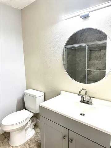 a bathroom with a sink mirror and toilet