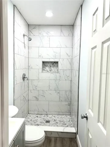 a bathroom with a granite countertop sink toilet and shower