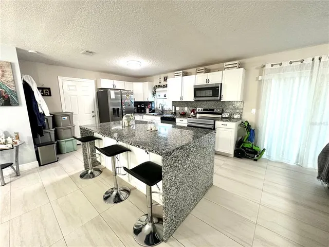 a living room with furniture a flat screen tv and a large window