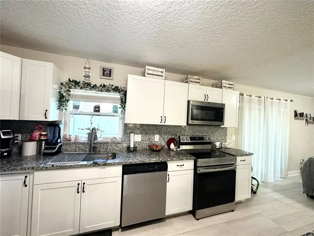 a kitchen with stainless steel appliances a stove a sink and a microwave