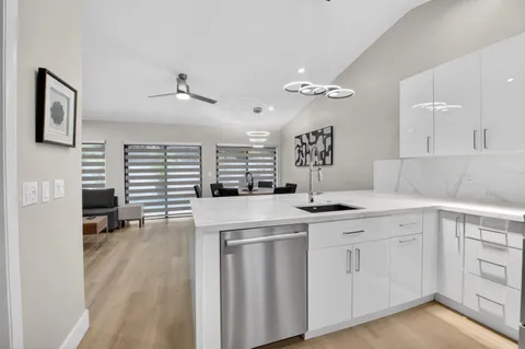 a kitchen with white cabinets and chandelier