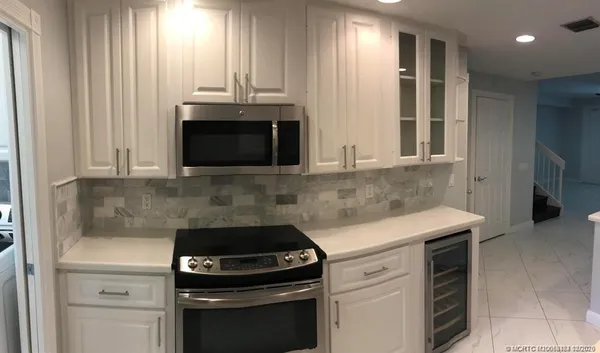 a kitchen with granite countertop white cabinets and white appliances