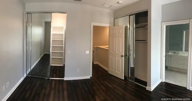 a view of a hallway with wooden floor and cabinets