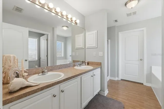 a bathroom with double vanity sinks and a mirror