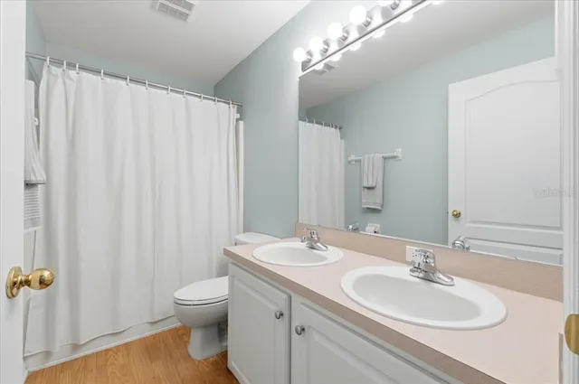 a bathroom with a double vanity sink mirror and toilet