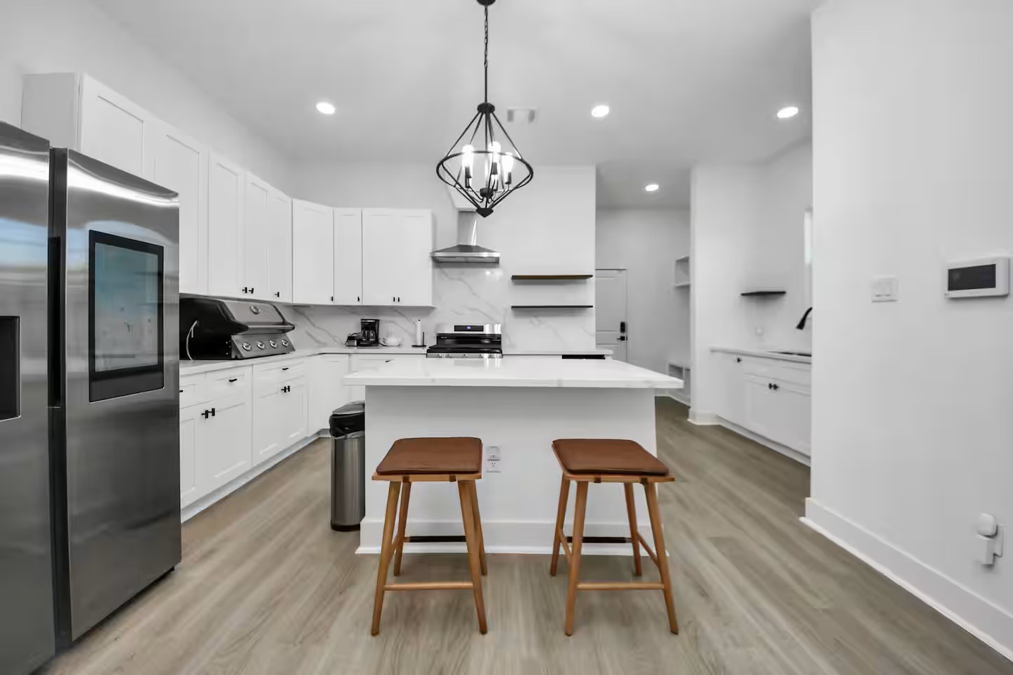 6747 Peerless Street Houston, TX 77021 - Photo 4 of 33 a kitchen with stainless steel appliances a table chairs wooden floors and cabinets