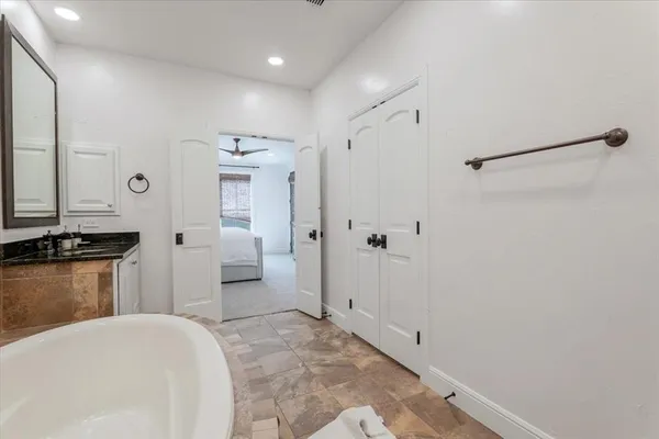 a spacious bathroom with a granite countertop sink and a mirror