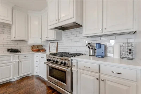 a kitchen with granite countertop white cabinets and stainless steel appliances