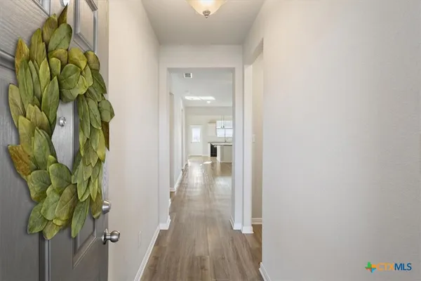 a view of a hallway with wooden floor