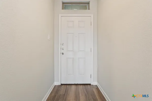 a view of a hallway with wooden floor