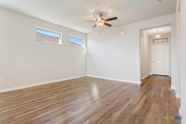 a view of an empty room with wooden floor