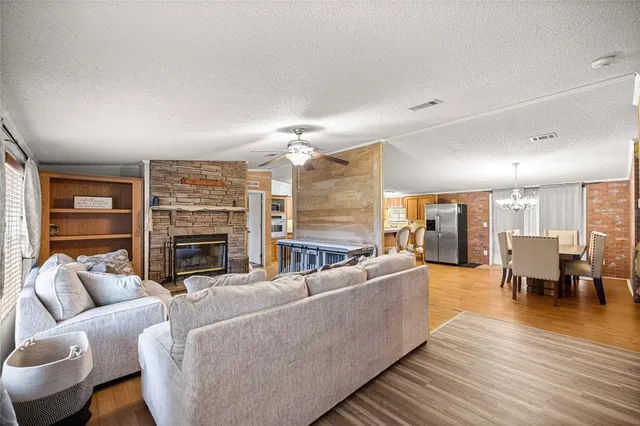 a living room with furniture two large window and a chandelier