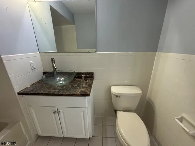 a bathroom with a granite countertop toilet and a sink