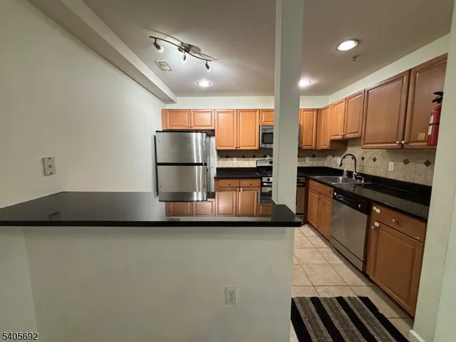 a kitchen with stainless steel appliances a sink stove and refrigerator