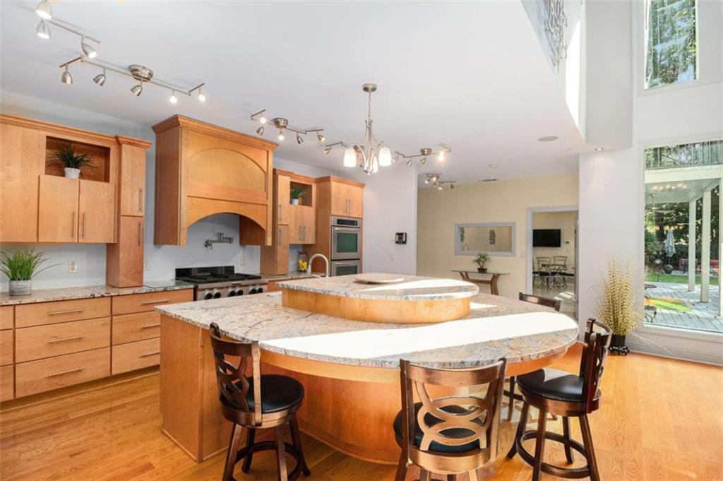 2994 East Ramble Lane Decatur, GA 30033 - Photo 14 of 111 a kitchen with kitchen island a stove a sink a dining table and chairs