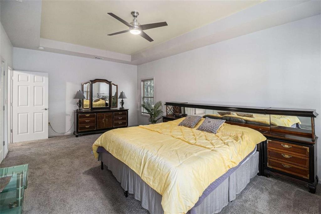 2994 East Ramble Lane Decatur, GA 30033 - Photo 74 of 111 a spacious bedroom with a bed a dresser and mirror