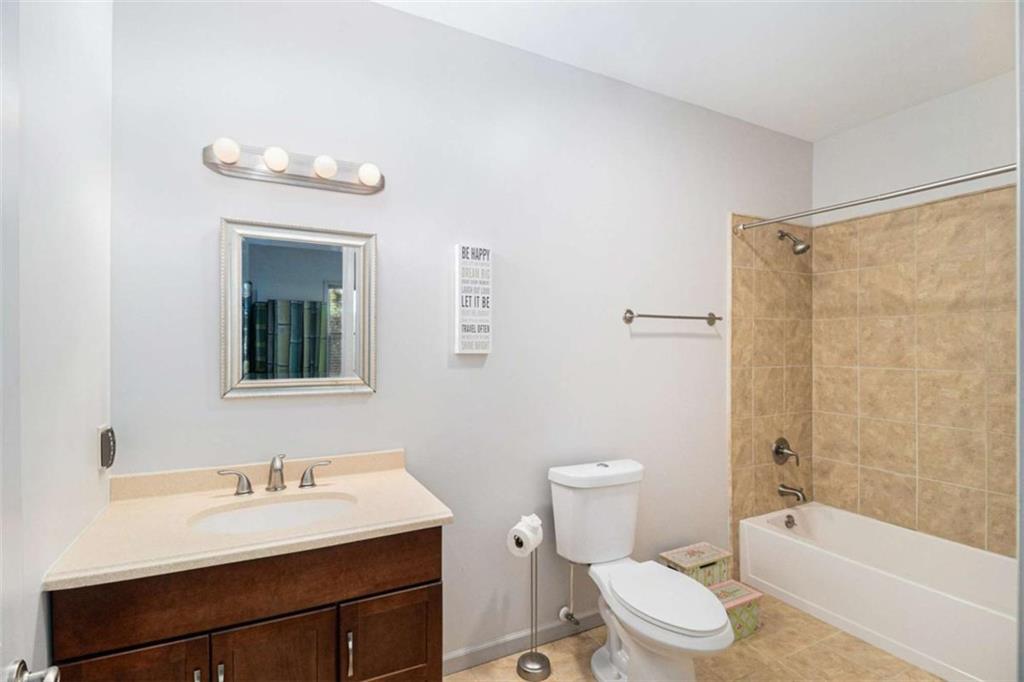 2994 East Ramble Lane Decatur, GA 30033 - Photo 79 of 111 a bathroom with a sink a toilet a mirror a vanity a bathtub and shower