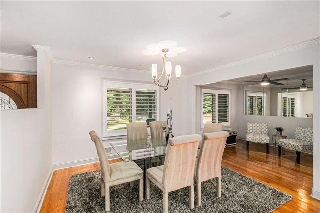 2994 East Ramble Lane Decatur, GA 30033 - Photo 8 of 111 a dining room with wooden floor a chandelier a wooden table and chairs