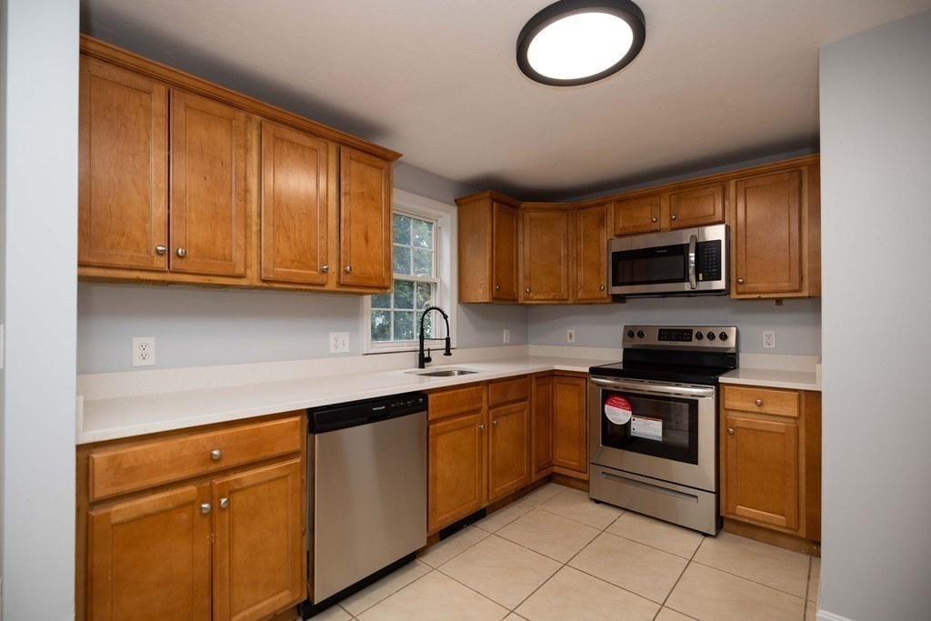 32 Rodney Street Worcester, MA 01605 - Photo 7 of 37 a kitchen with stainless steel appliances granite countertop a sink stove and microwave