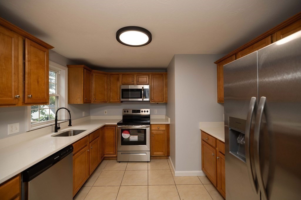 32 Rodney Street Worcester, MA 01605 - Photo 8 of 37 a kitchen with stainless steel appliances granite countertop a sink stove and refrigerator