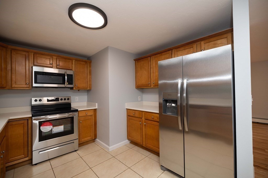 32 Rodney Street Worcester, MA 01605 - Photo 9 of 37 a kitchen with stainless steel appliances granite countertop a refrigerator a stove and a sink