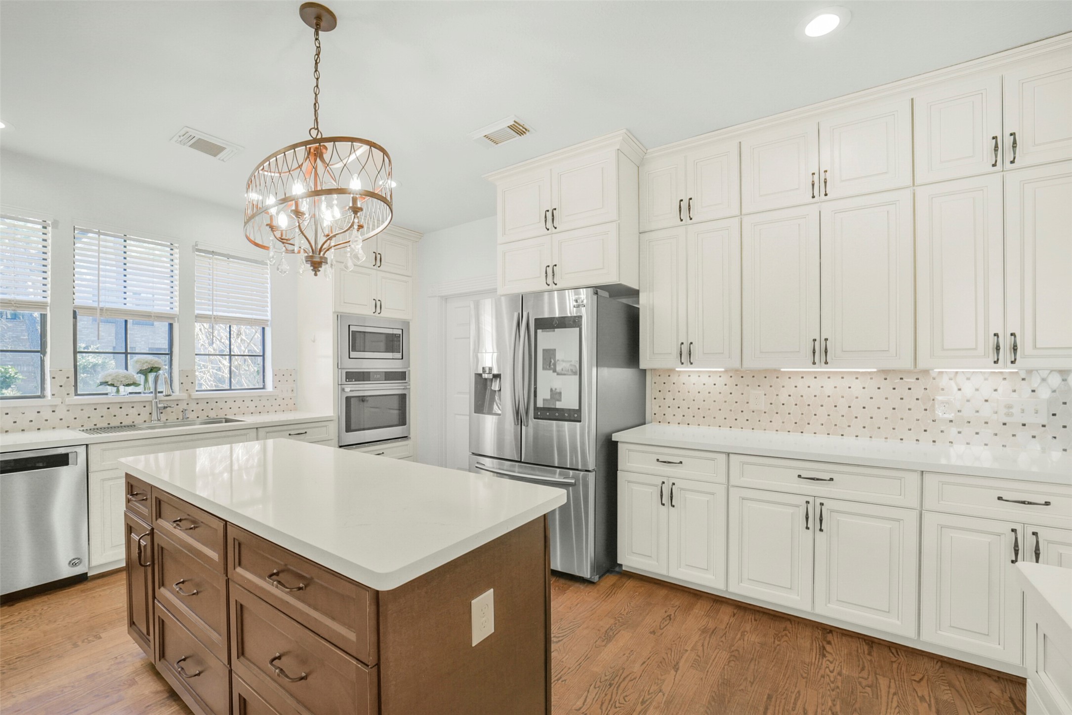 17302 Atherington Place Spring, TX 77379 - Photo 17 of 50 Striking oak floors with walnut inlay flow through the kitchen, adding warmth and custom character.