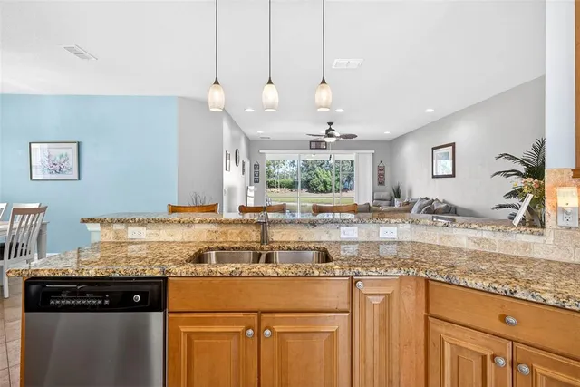 a kitchen with granite countertop a sink stove and cabinets