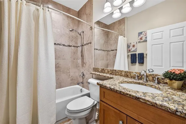a bathroom with a granite countertop shower a sink and a mirror