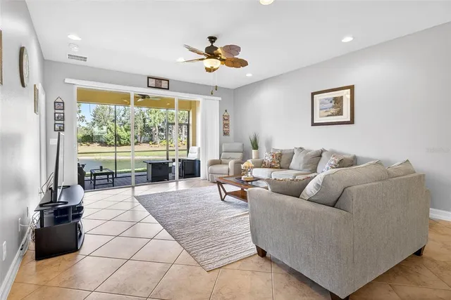 a living room with furniture kitchen view and a chandelier