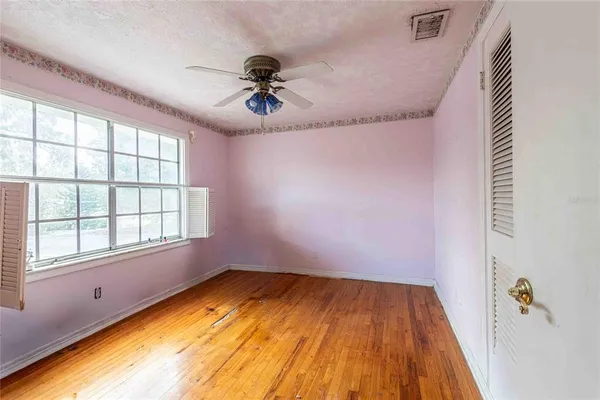 wooden floor in an empty room with a window