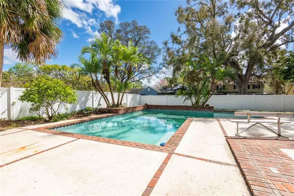 a view of backyard with swimming pool and sitting area
