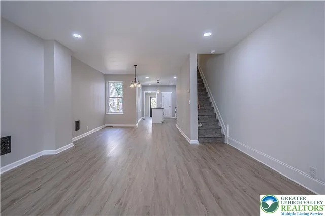 a view of hallway with wooden floor and staircase