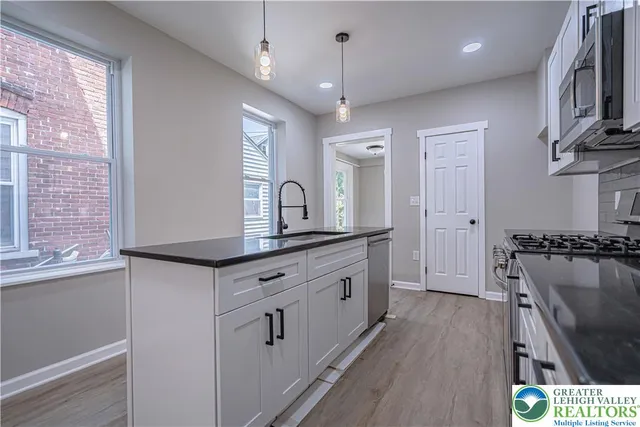 a spacious bathroom with a granite countertop sink a mirror a vanity and a shower