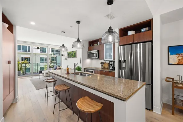 a kitchen with granite countertop a center island a sink stainless steel appliances and cabinets