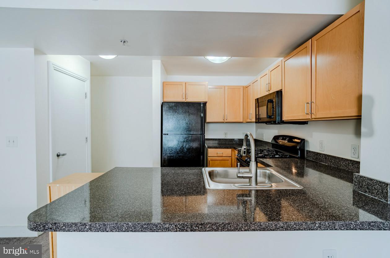 800 4th Street Southwest, Unit S501 Washington, DC 20024 - Photo 3 of 26 a kitchen with stainless steel appliances granite countertop a sink a stove and a cabinets