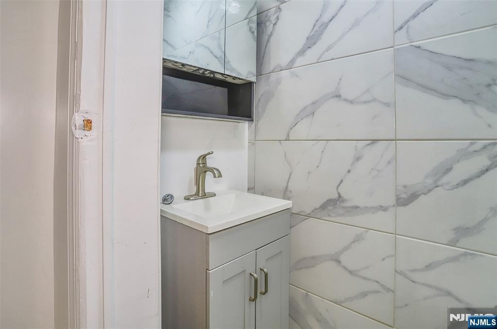 9017 Riverside Place North Bergen, NJ 07047 - Photo 6 of 27 a bathroom with a sink vanity and a shower