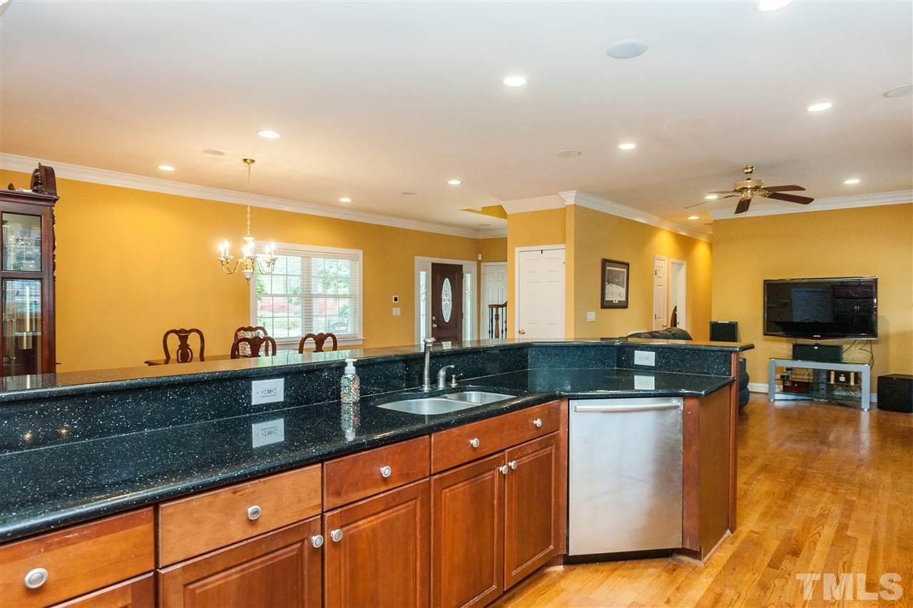 6428 Brandywine Road Raleigh, NC 27607 - Photo 8 of 25 a large kitchen with stainless steel appliances a large counter top a stove a sink a dining table and chairs
