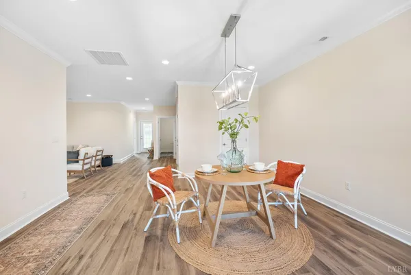a view of a dining room and livingroom with furniture wooden floor a chandelier
