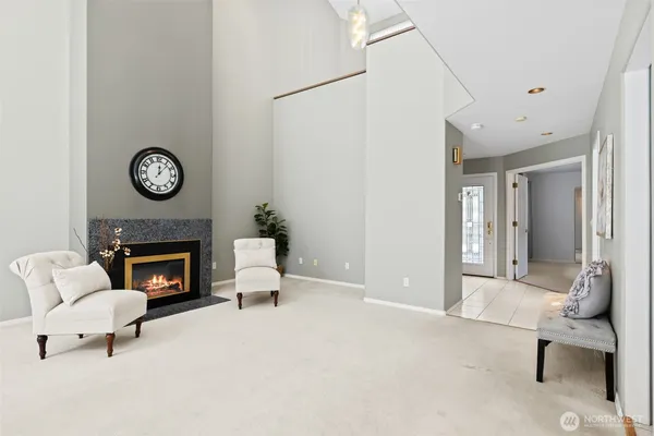 a living room with furniture a fireplace a clock and a fireplace