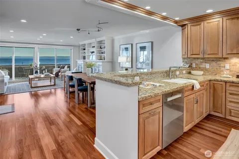 a kitchen with stainless steel appliances granite countertop a lot of counter space and wooden floors