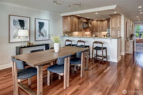 a kitchen with granite countertop a table chairs microwave and cabinets