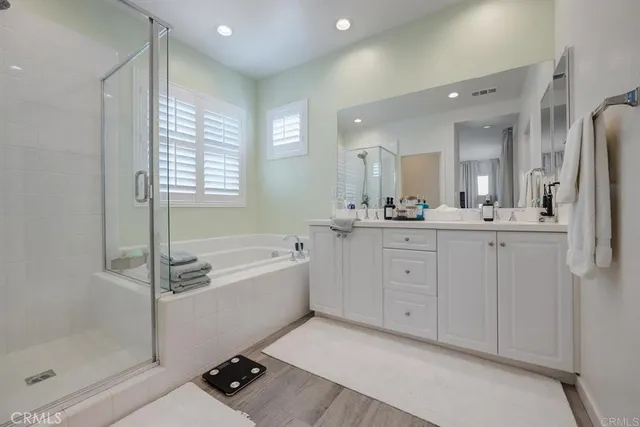 a spacious bathroom with a double vanity sink a mirror and a bathtub