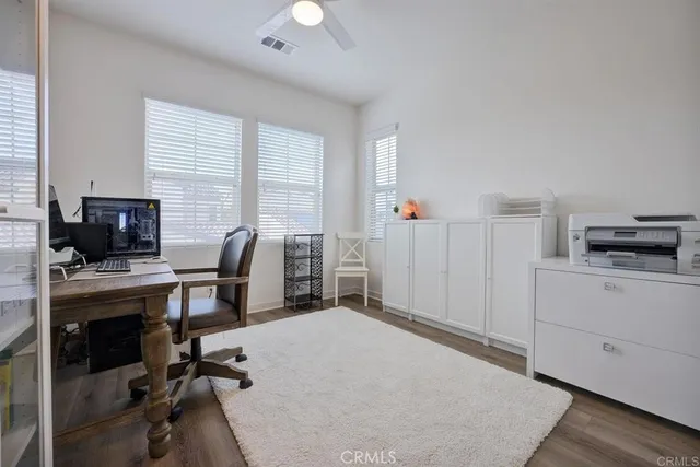 a view of a workspace with furniture and a window