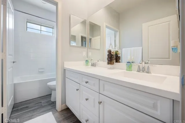 a bathroom with a tub a sink and a large mirror
