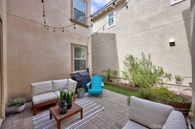 a view of a patio with couches and a table and chairs with wooden floor